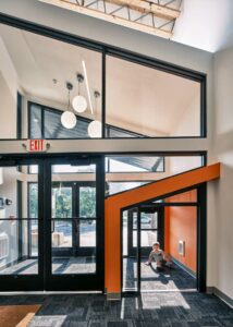 child on floor seen through child-sized entrance to school